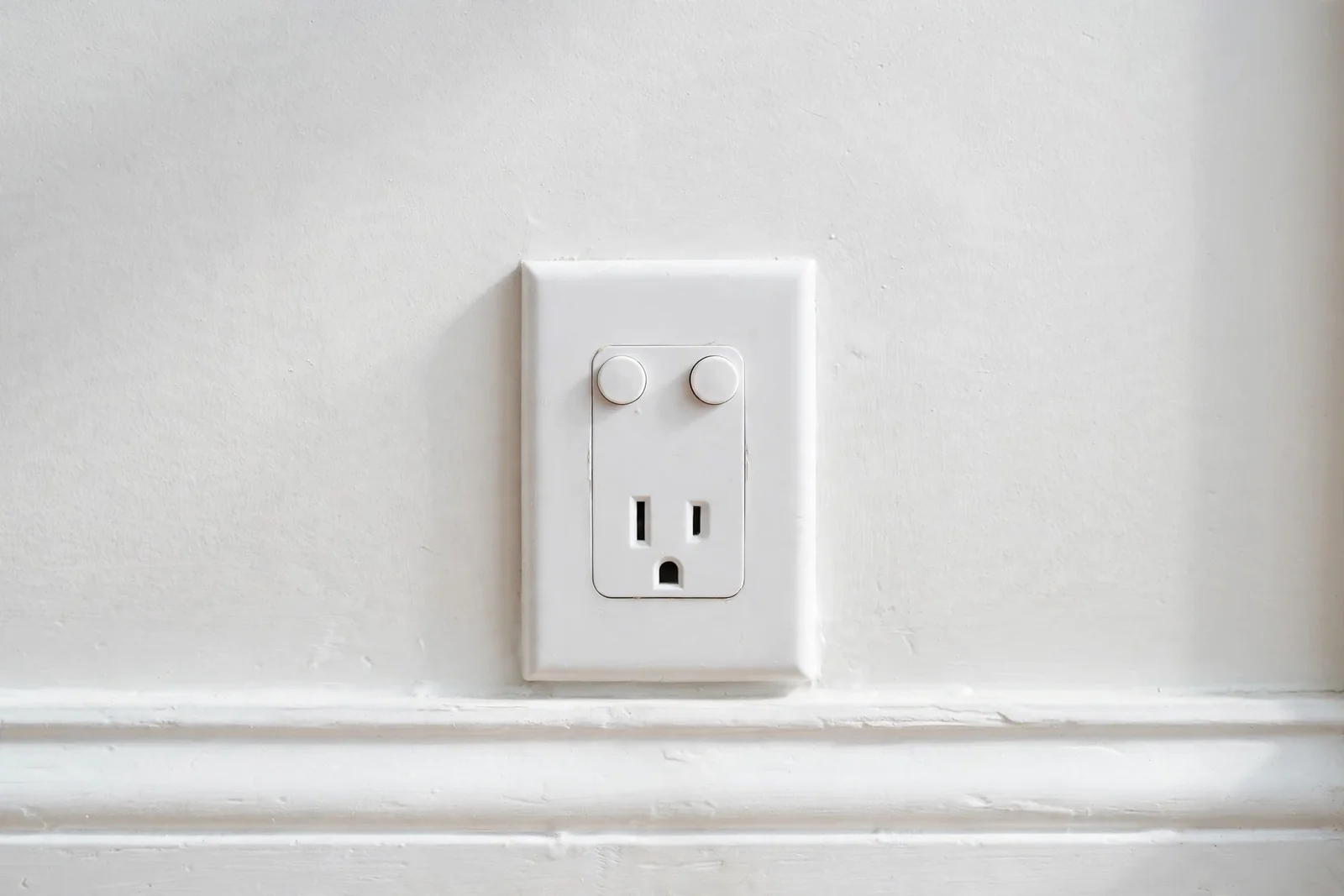 A GFCI outlet near a baseboard, part of water damage electrical safety